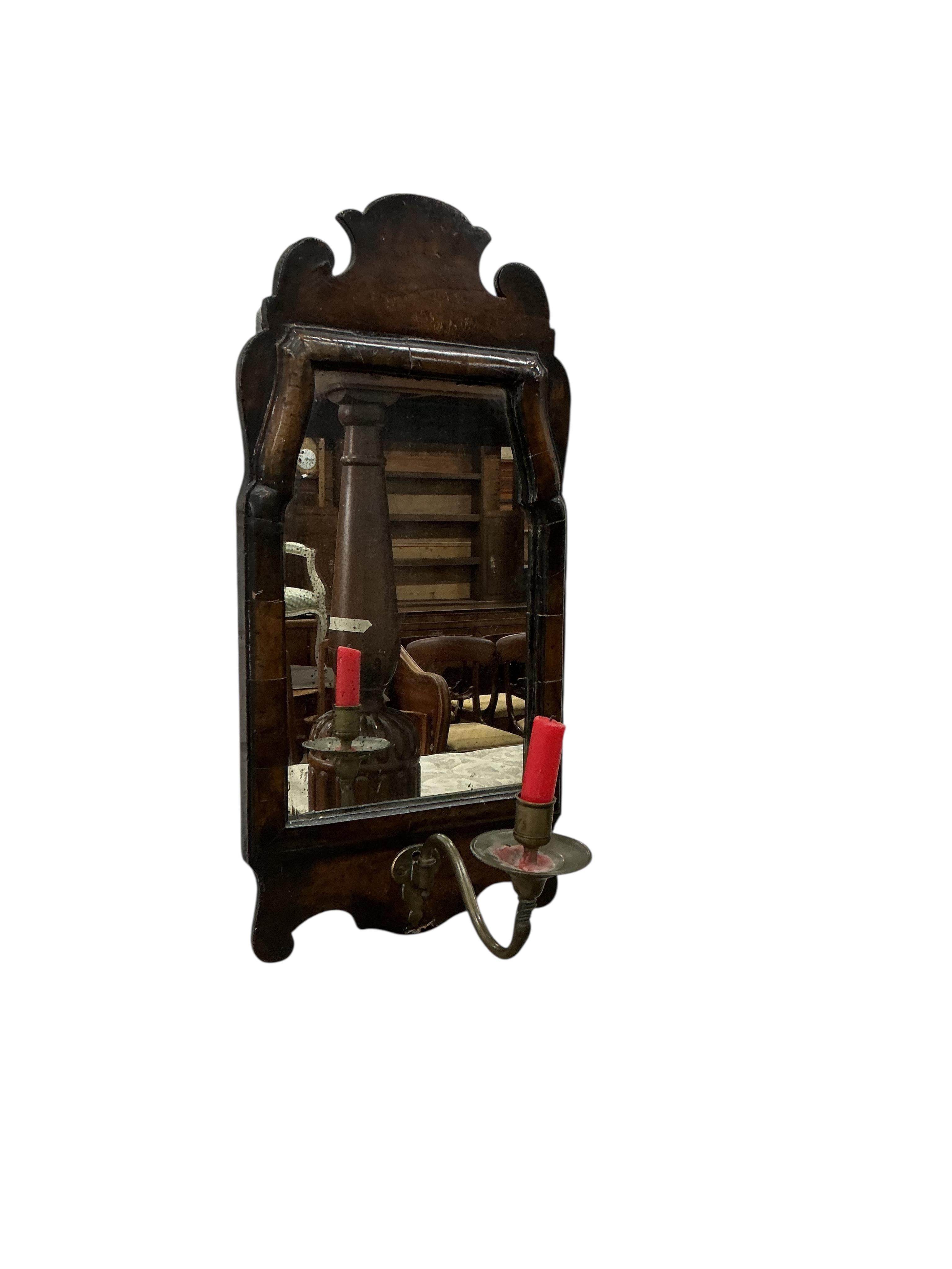 A small 18th century style walnut fret cut wall mirror, with a brass candle sconce, width 24cm, height 50cm